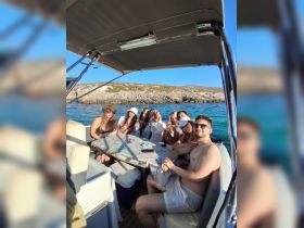 A cheerful group of friends enjoys a sunny day on a boat, capturing memories together — perfect for summer outings and celebrations on the water.