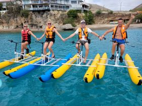 A group of friends enjoys a fun day on waterbikes, showcasing adventure and camaraderie in the beautiful ocean waters.