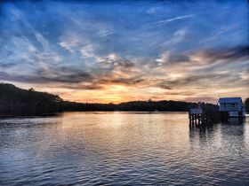 A stunning sunset over a tranquil harbor, showcasing the serene beauty of nature — perfect for evening boat trips or peaceful reflections by the water.