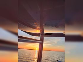 A stunning sunset view from the deck of a boat, capturing the serene waters and vibrant colors of the evening sky — perfect for peaceful evening cruises.