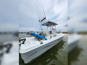 A sleek fishing boat equipped with multiple fishing rods and a kayak, ready for an exciting day on the water.