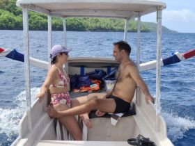A couple relaxes on a boat, enjoying the ocean breeze and each other's company — a perfect moment for romantic getaways or leisurely boat trips.