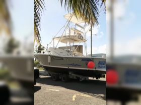 A fishing boat is being transported on a trailer, showcasing its sleek design and readiness for the water.