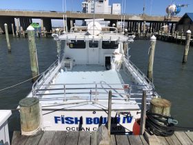 A clear view of the 'Fish Bound IV' fishing boat docked at the pier, showcasing its spacious deck and structure, ideal for fishing trips in Ocean City, MD.