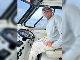 A captain at the helm of a boat, showcasing the interior console and steering setup — perfect for navigating the open waters.