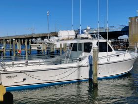 A pristine view of a boat named 'Evans 32' docked at the pier, showcasing its sleek design against a clear blue sky.