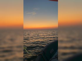 A serene sunset view from the bow of a boat, showcasing the tranquil ocean and vibrant sky colors — perfect for peaceful evening cruises.