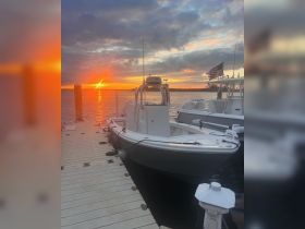 A serene sunset view featuring a speedboat docked at the marina, perfect for evening cruises and relaxation on the water.