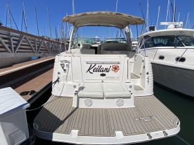 A clear view of the back of the 'Keilani' yacht docked at the marina, showcasing its elegant design and spacious seating area.