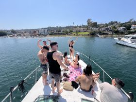A lively group enjoys a sunny day on a boat, celebrating with friends and soaking up the sun — the perfect backdrop for summer fun on the water.