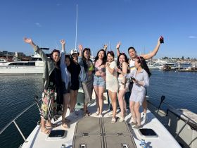A lively group of friends celebrates on the deck of a boat, showcasing the joy of summer outings and memorable gatherings on the water.