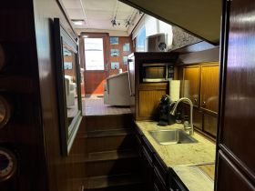 Interior view of a boat's kitchen area, showcasing modern amenities and a cozy seating space, perfect for onboard dining and relaxation.