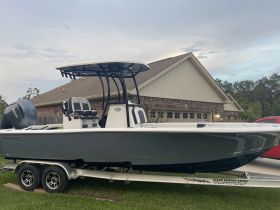 A sleek fishing boat is showcased on a trailer, highlighting its modern design and features, perfect for outdoor adventures.