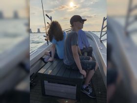 A group of young guests enjoys a scenic boat ride at sunset, creating a perfect backdrop for fishing and relaxation on the water.