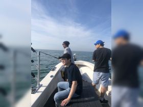 A group of friends enjoys a fishing trip on a boat, capturing the excitement of a day on the ocean.