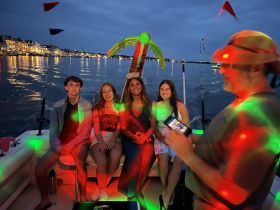 A lively group enjoys a festive night on the boat, celebrating with colorful lights and a fun atmosphere — perfect for memorable gatherings on the water.