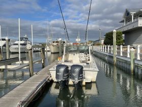A center console boat docked at the marina, surrounded by other vessels, showcasing a serene boating environment.
