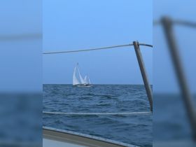 A serene view of a sailboat navigating through calm waters, captured during twilight — perfect for showcasing sailing adventures.