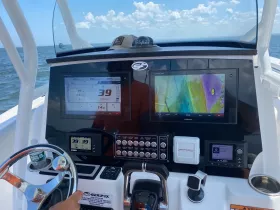 A detailed view of the helm and console of a boat, showcasing advanced navigation equipment and controls, perfect for boating enthusiasts and captains.