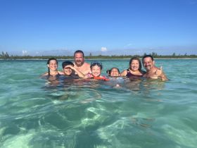 A joyful family enjoys a fun day swimming in crystal-clear waters, creating unforgettable memories together in a tropical paradise.