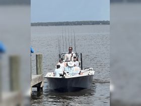 A group of friends enjoys a fishing trip on a boat, showcasing the excitement of on-water activities and camaraderie.