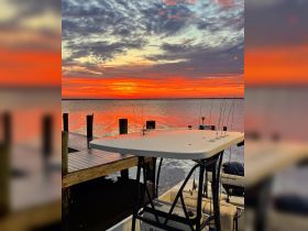 A stunning sunset view featuring a Blazer Bay boat docked at the pier, creating a picturesque scene perfect for evening relaxation on the water.