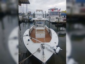 A clear view of a fishing boat docked at the marina, showcasing its sleek design and equipped with modern fishing gear.