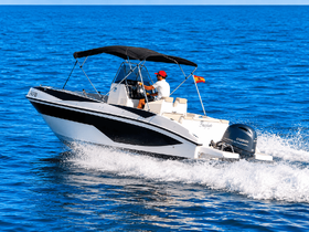 A speedboat glides through the clear blue waters with a captain at the helm, showcasing the thrill of boating adventures on the open sea.