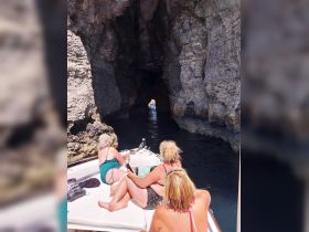 A group of friends enjoys a scenic boat ride through a stunning cave, capturing the essence of adventure and exploration on the water.