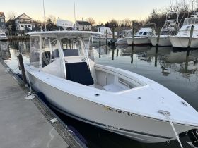 A sleek speedboat docked at the marina, showcasing its modern design and pristine condition, perfect for a day on the water.