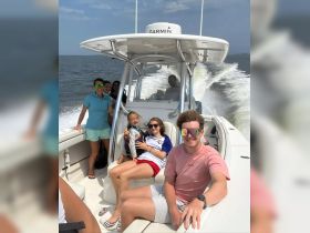 A joyful family enjoys a fun day on the water aboard a boat, capturing smiles and laughter as they cruise along the waves.