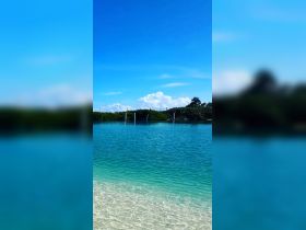 A serene view of clear waters and a blue sky, perfect for showcasing beautiful coastal destinations.
