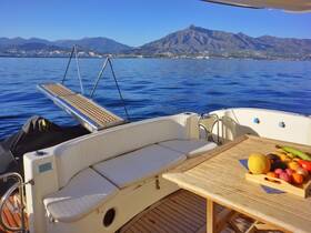 A cozy interior view of a boat featuring a dining area with a fruit platter, perfect for enjoying meals while cruising on calm waters.