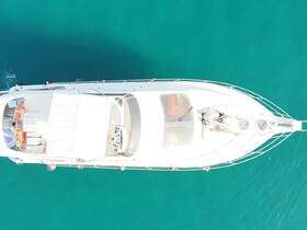 An aerial view of a couple relaxing on the deck of a luxurious yacht, surrounded by stunning turquoise waters — perfect for romantic getaways or leisure cruises.