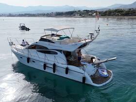 A group enjoys a relaxing day aboard a yacht, cruising through calm waters with stunning mountain views in the background.