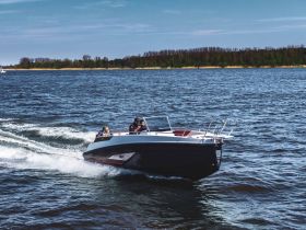 A speedboat glides across the water with passengers enjoying a thrilling ride — perfect for adventure seekers on the open water.
