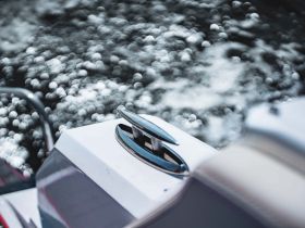 An unclear image featuring a part of a boat with blurred water in the background, lacking identifiable details.