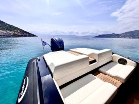 A sleek boat with luxurious seating and a Greek flag, anchored in tranquil waters, showcasing the perfect setting for a day on the sea.
