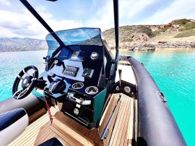 A sleek view of the helm and console inside a modern boat, showcasing advanced navigation equipment and luxurious seating — perfect for a day on the water.