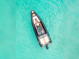 A stunning aerial view of a sleek speedboat gliding over crystal-clear turquoise waters, perfect for exploring coastal destinations.