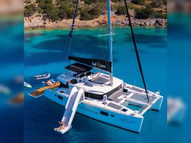 A thrilling moment on a catamaran with a water slide, showcasing guests enjoying the crystal-clear waters — perfect for adventure seekers and family fun in the sun.