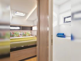 A cozy cabin interior featuring a comfortable bed adorned with colorful pillows, perfect for relaxing on a boat getaway.