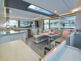 A beautifully designed interior of a yacht featuring a spacious dining area and modern amenities, perfect for entertaining guests on board.