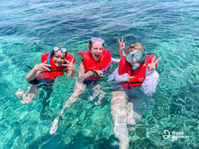 Three friends enjoy a lively snorkeling adventure in crystal-clear waters, showcasing the joy of underwater exploration and group fun.