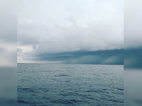 A dramatic view of a stormy sky over the ocean, capturing the mood of an impending weather change.