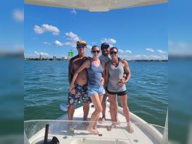 A group of friends poses together on a boat, enjoying a sunny day on the water — perfect for memorable outings and celebrations.