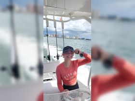 A young girl smiles while on a fishing boat, showcasing the joy of a day on the water. Perfect for family fishing trips and ocean adventures.