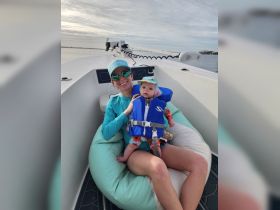 A joyful moment on the water as a mother and her baby enjoy a relaxing day on the boat, showcasing family fun and bonding in a beautiful setting.