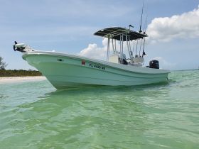 A sleek speedboat anchored in clear turquoise waters, showcasing its design and fishing gear, perfect for a day on the water.
