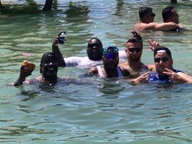 A lively group of friends enjoys a fun day in the water, celebrating with drinks and laughter — perfect for a memorable day on the water.